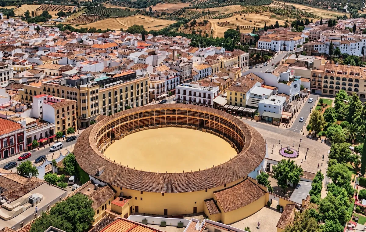 Aerial view of the Plaza de Toros de Ronda, its sand ring and covered stands, in the middle of the town