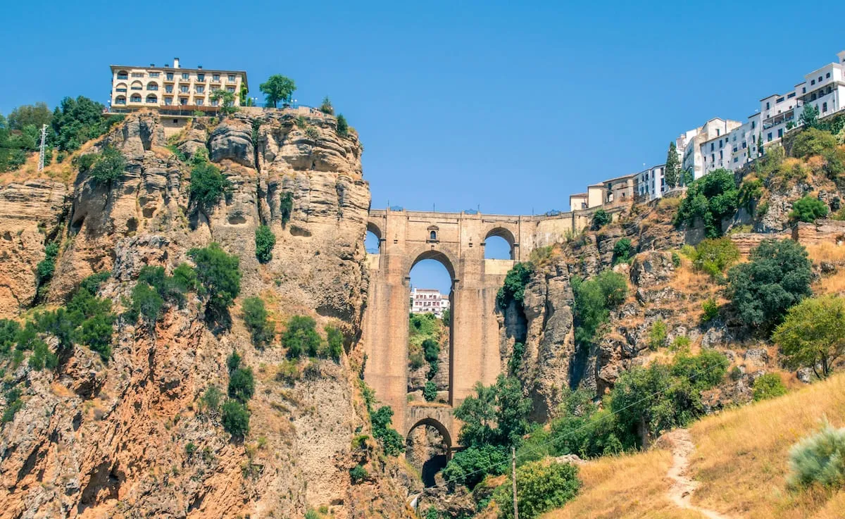 The Puente Nuevo seen from below, between the cliffs of the Tajo gorge, with a footpath in the foreground
